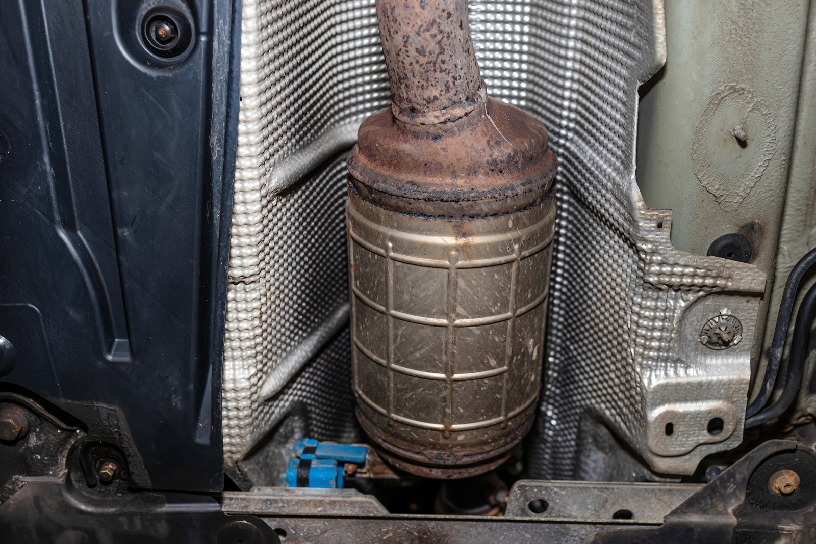 Diesel particulate filter in the exhaust system of a car raised on a workshop lift