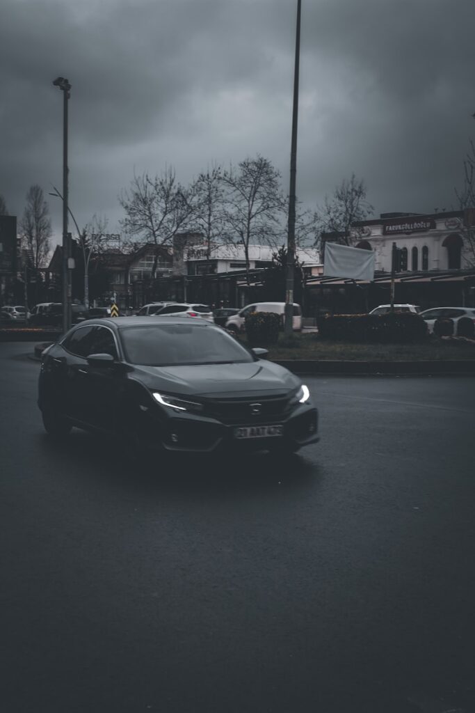 a car driving down a street under a cloudy sky
