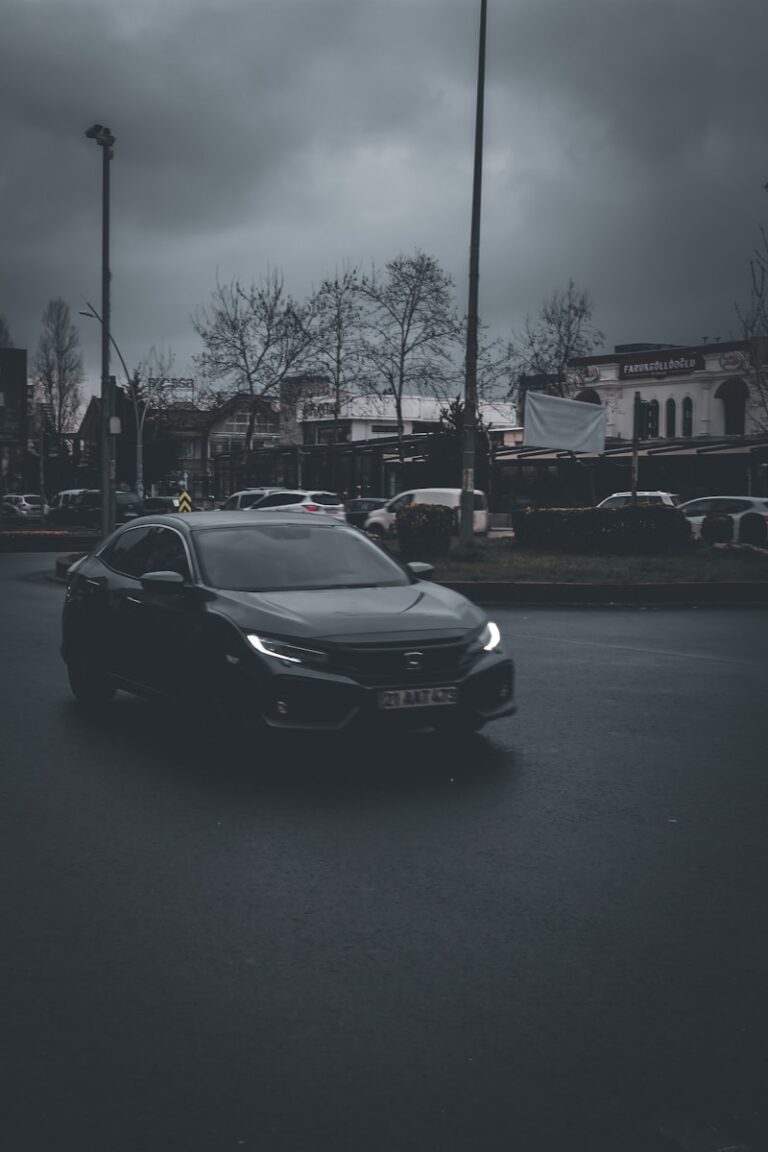 a car driving down a street under a cloudy sky
